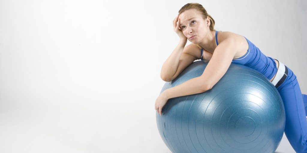 Frustrated woman on exercise ball