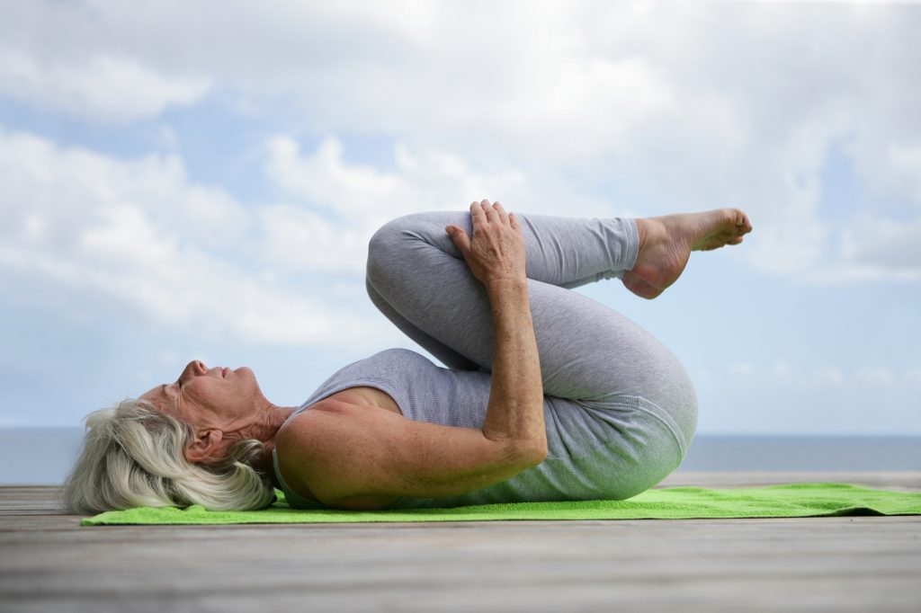 Woman doing yoga on jetty